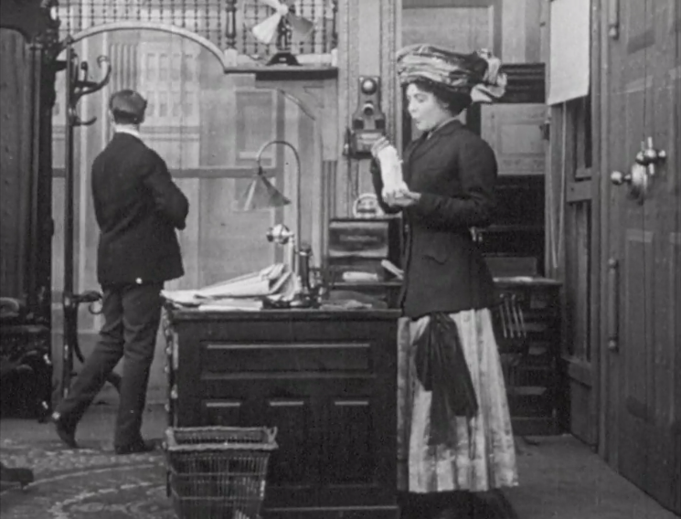 Still from silent film showing a man and a woman in late victorian dress